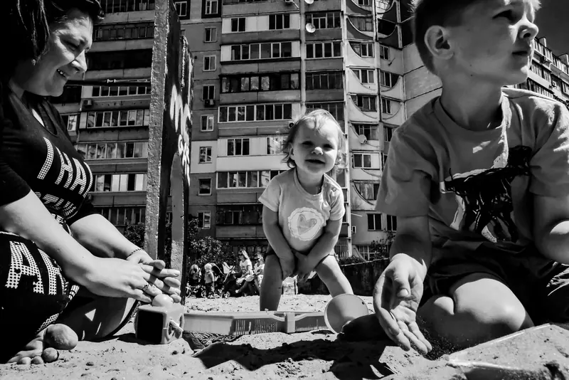 Mutter und Kinder vor Plattenbauten
